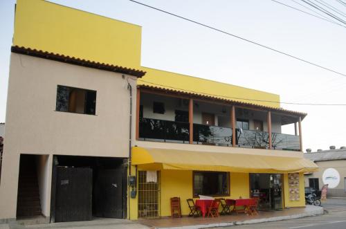 佩尼多Aconchego Fabuloso的前面有红色桌子的黄色建筑