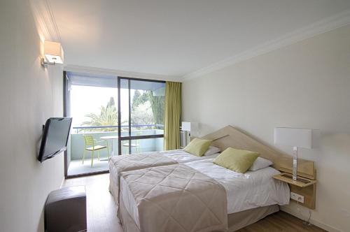 格拉斯勒斯赛德雷斯阿克乡村度假酒店的一间白色卧室,配有床和阳台