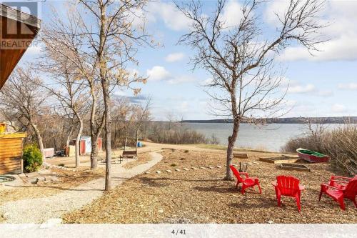 SiltonMy Lovely Lakeview Cottage Saskatchewan Beach 3 Bed - 2 Bath Cabin的一组红色椅子坐在湖边