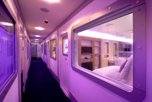 史基浦阿姆斯特丹史基浦优特艾尔过境酒店的一间医院房间走廊,有紫色的灯光
