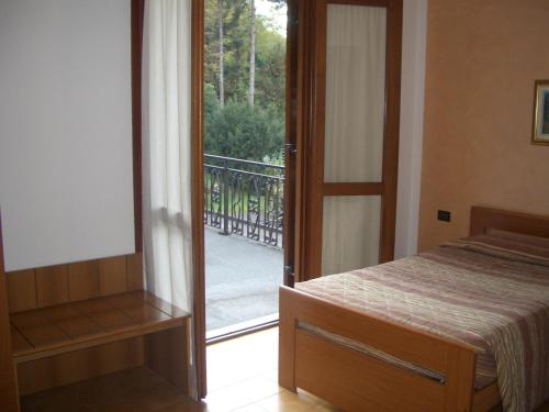 波里奥特米Albergo Il Castellino的卧室设有通往阳台的门