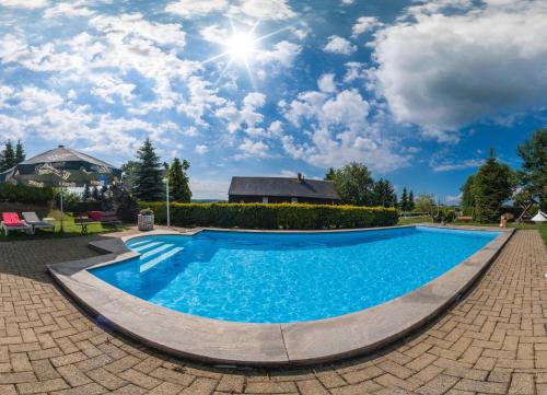 MarkneukirchenHotel Alpenhof的蓝色天空的院子中的游泳池