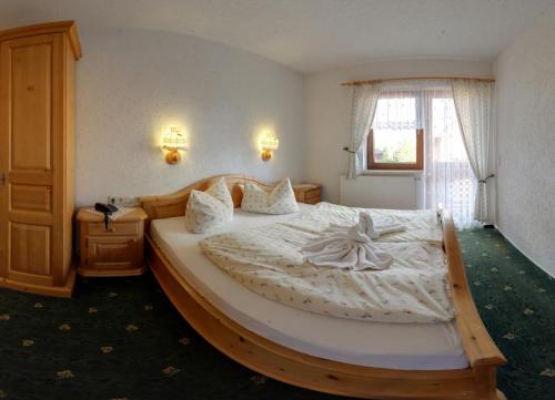 MarkneukirchenHotel Alpenhof的一间卧室配有一张木架大床