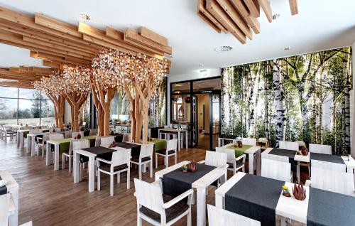 AscheffelPanorama Hotel Aschberg的一间设有桌椅和树木的餐厅
