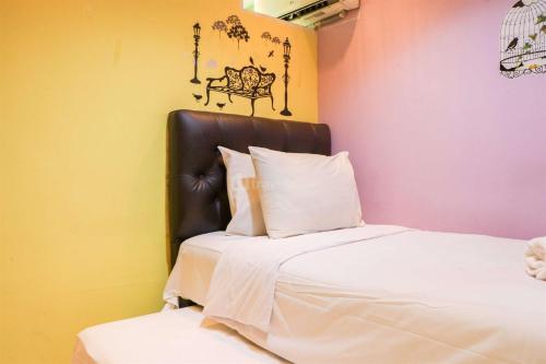 万隆Cozy 2BR at Buah Batu Park Apartment By Travelio的一间卧室配有一张带黑色皮革床头板的床