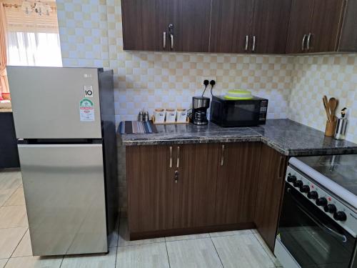 KigoFully furnished 3 bedroom apartment in Mirembe Villas Kigo, Uganda的厨房配有冰箱和台面