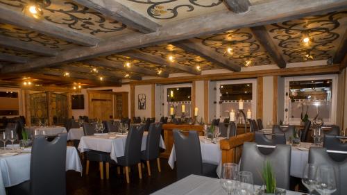 阿尔特施泰滕巴多弗酒店的一间带桌椅和天花板的用餐室