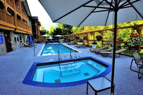彭伯顿彭伯顿山谷旅馆的一个带遮阳伞和桌椅的游泳池