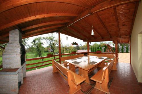 肯普隆格Pensiunea Valea Ursului的一个带桌子和壁炉的大型木制凉亭