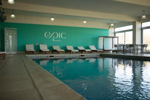 拉蓬塔圣路易斯史诗酒店​​的大楼内一个带桌椅的游泳池