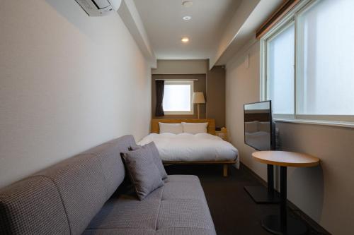 札幌The Stay Sapporo Annex的一间配有沙发、一张床和窗户的客房