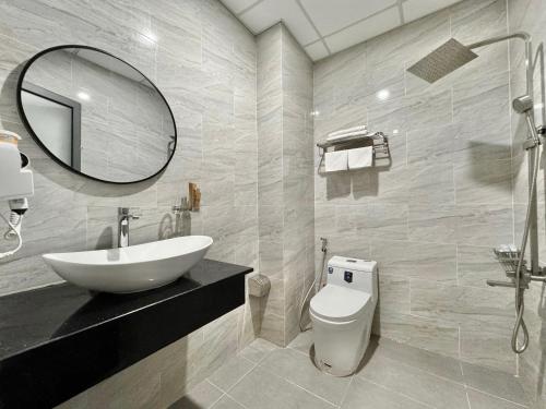 芹苴LION 5 HOTEL的一间带水槽、卫生间和镜子的浴室