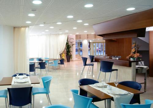 洛格罗尼奥穆列塔酒店的一间设有蓝色桌椅的餐厅和一间酒吧