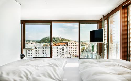 格拉茨Hotel Daniel Graz - Smart Luxury Near City Centre的一间卧室设有一张大床和一个大窗户