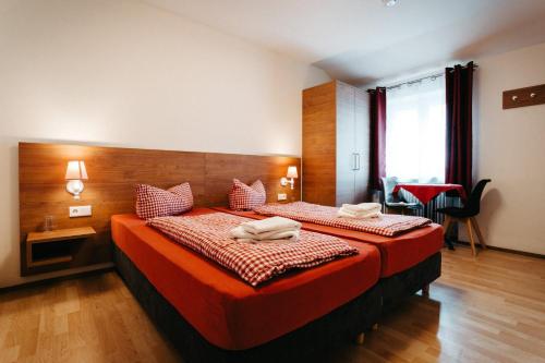 埃赫施塔特保加斯霍夫小号酒店的酒店客房,配有一张带红色床单的大床