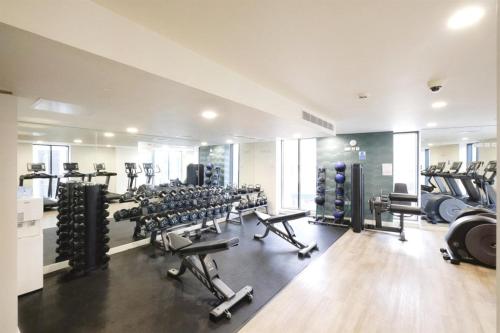 伯明翰Skyline Penthouse City Centre Birmingham Free Gym access and PS4的健身房,配有许多跑步机和机器