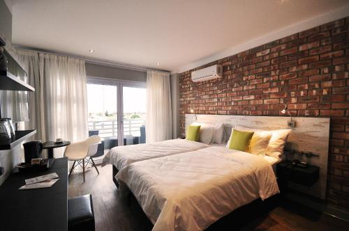 斯瓦科普蒙德Swakopmund Plaza Hotel的一间带砖墙和大床的卧室
