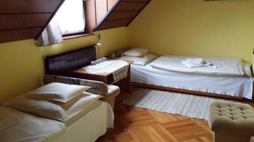 科马罗姆Kocsis Panzió és Étterem的一间设有两张床和一张桌子及椅子的房间
