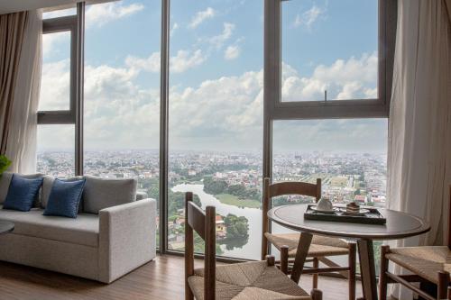 海阳Mandala Hotel & Suites Hai Duong的客厅配有沙发和窗户前的桌子