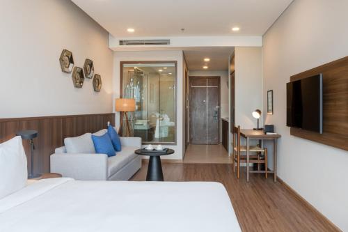 海阳Mandala Hotel & Suites Hai Duong的酒店客房设有床和客厅。