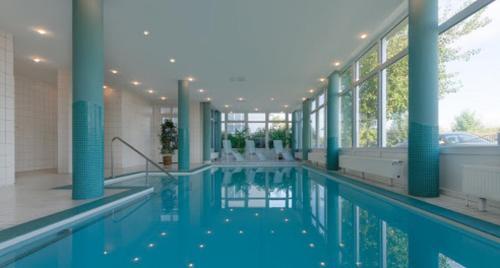 瓦尔内明德希布里克公园酒店的一座蓝色柱子的大型游泳池和一座建筑