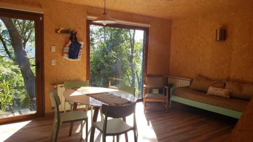 圣卡洛斯-德巴里洛切Refugio Churrin的客房设有桌子、沙发和窗户。