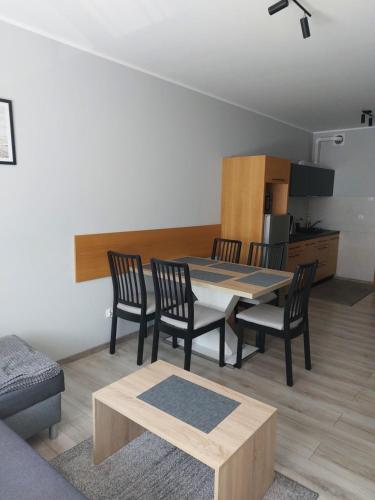 科沃布热格Komfortowy apartament w zachodniej części Kołobrzegu的客厅设有餐桌和椅子