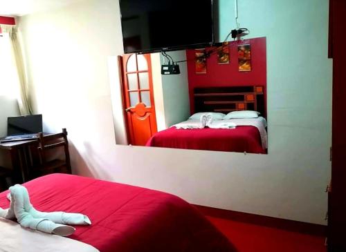 胡利亚卡WIRACOCHA Hostal的红色卧室设有两张床和镜子