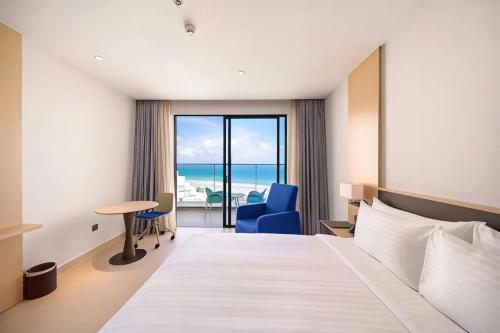 Miếu ÔngArena Cam Ranh Bay Resort的酒店客房设有一张床,享有海景。
