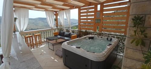 格雷巴蒂卡Holiday Home Peran的带阳台的带热水浴缸的客房