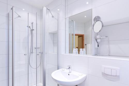 杜塞尔多夫多利纳酒店的白色的浴室设有水槽和淋浴。