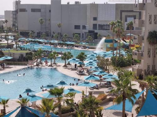 莫纳斯提尔Palm lake resort Folla Monastir的享有带人员和遮阳伞的度假村游泳池的空中景致