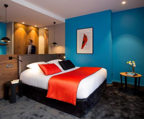 第戎红帽子酒店的酒店客房设有一张带红色毯子的大床