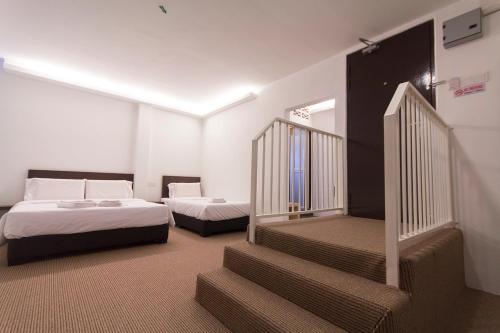 劳勿HOTEL RAUB since 1968的酒店客房带两张床和楼梯