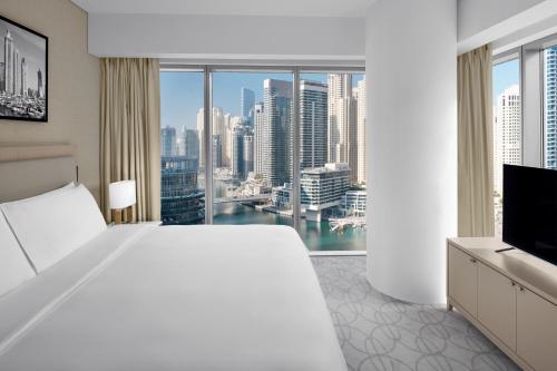 迪拜JW Marriott Hotel Marina的卧室设有一张白色大床和大窗户