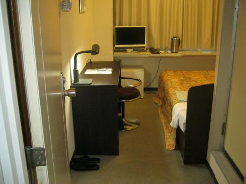 德岛阿凡提酒店的客房设有一张床、一张桌子和一台电脑