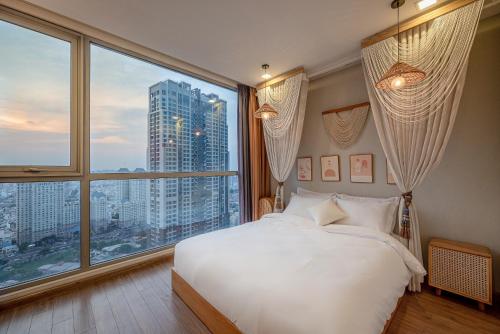 胡志明市Apartment in Landmark-Vinhome Central Park by Yen的卧室设有白色的床和大窗户
