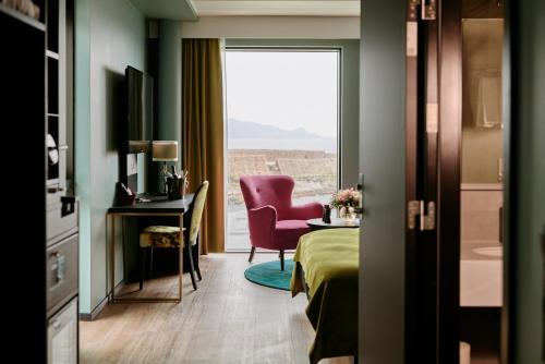 斯沃尔韦尔Thon Hotel Svolvær的酒店的客房 - 带一张床、椅子和窗户