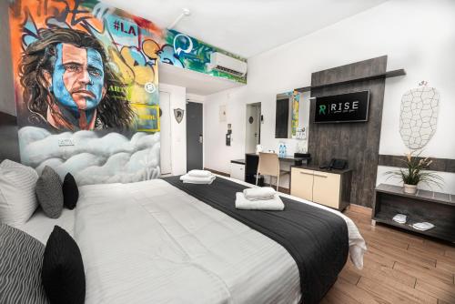 拉纳卡Rise Street Art Hotel的卧室配有一张大床,墙上挂有绘画作品