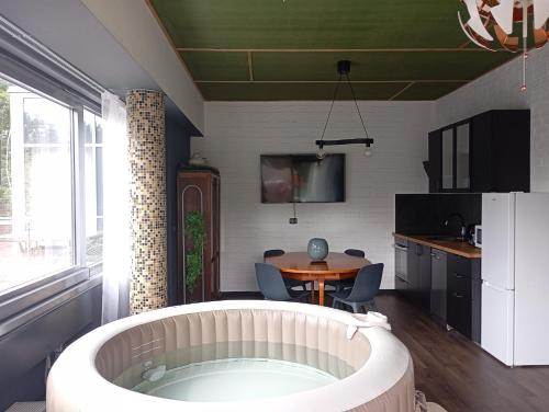 拉脱维亚索露丝俱乐部公寓的带浴缸和桌椅的厨房