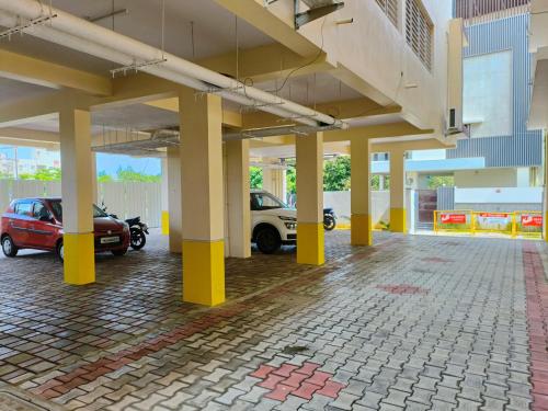 钦奈Neighbour Inn - Apart Hotel的一个空的停车场,有黄色的柱子和汽车