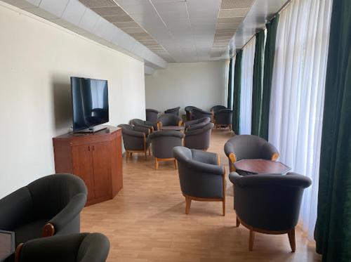 希欧福克Aranypart Hostel的一间设有椅子和平面电视的等候室