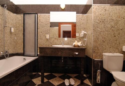贝内绍夫科诺皮什切度假村酒店的一间带水槽、浴缸和卫生间的浴室