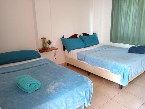 佩达西镇Residencial Santa Catalina Pedasi的两张睡床彼此相邻,位于一个房间里