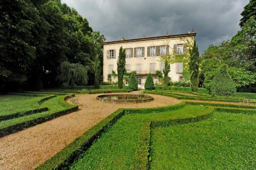 蒂耶尔Chateau De La Chassaigne的一座花园,花园内设有一座大建筑和一个喷泉