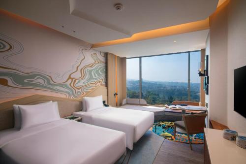 万隆Hotel Indigo Bandung Dago Pakar, an IHG Hotel的酒店客房设有两张床和电视。