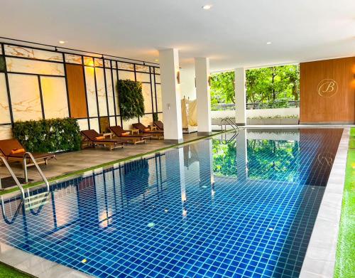 曼谷班飞亚唐森酒店的一座配有桌椅的酒店游泳池