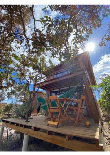 戈亚斯州上帕莱索Enchanted Cabins Chapada dos Veaderos的树屋,甲板上摆放着椅子