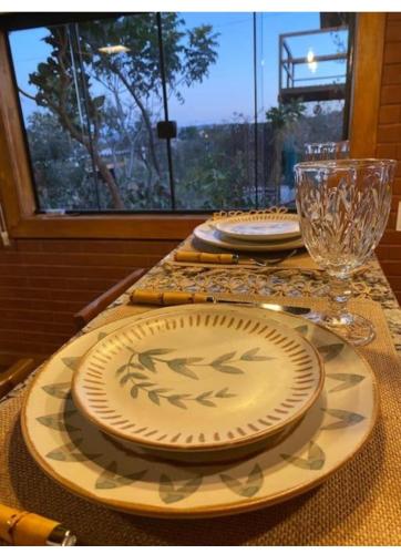 戈亚斯州上帕莱索Enchanted Cabins Chapada dos Veaderos的桌子上带盘子和玻璃杯的桌子