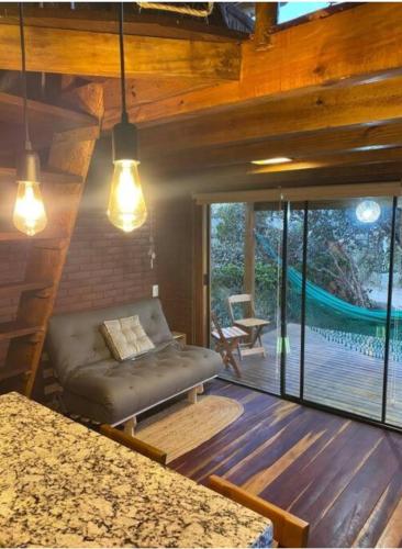 戈亚斯州上帕莱索Enchanted Cabins Chapada dos Veaderos的带沙发的客厅和天井。